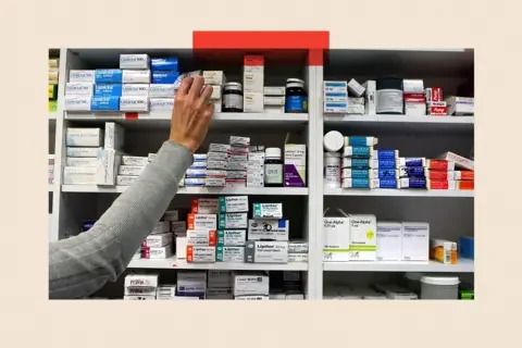 PA Wire A pharmacist stocks shelves at a chemist.